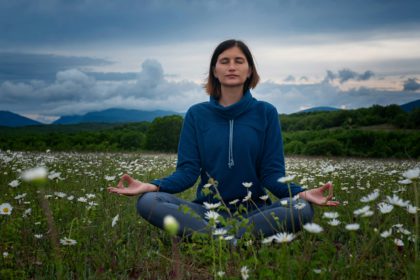 A young woman doing yoga in the field.