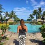 Beautiful woman in a tropical paradise by pool & palm trees in Maui Hawaii. Island life rules.