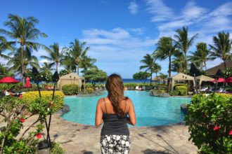 Beautiful woman in a tropical paradise by pool & palm trees in Maui Hawaii. Island life rules.