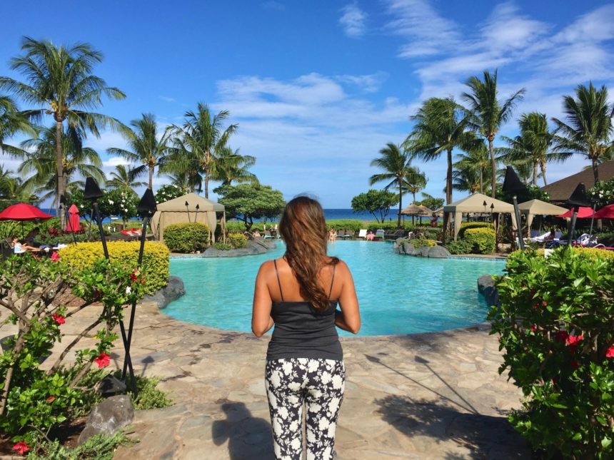 Beautiful woman in a tropical paradise by pool & palm trees in Maui Hawaii. Island life rules.