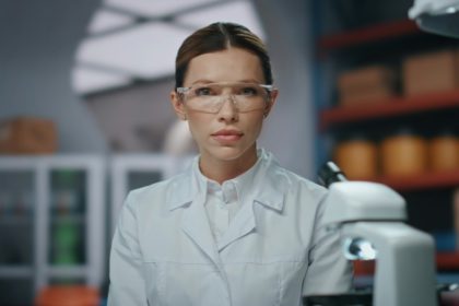 Confident medical scientist posing in advanced laboratory in glasses close up.