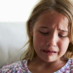 Head And Shoulders Shot Of Upset Girl At Home