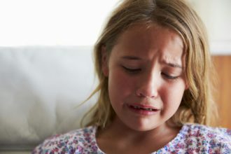 Head And Shoulders Shot Of Upset Girl At Home