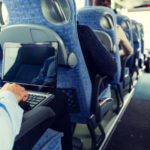 man with smartphone and laptop in travel bus