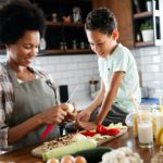 Mother and child having fun preparing healthy food in kitchen
