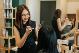 The makeup artist works in her salon, applies professional makeup.