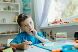 Thinking student doing his homework at home