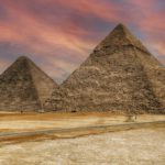 View of the pyramids of Giza in Egypt against a colorful sunset sky