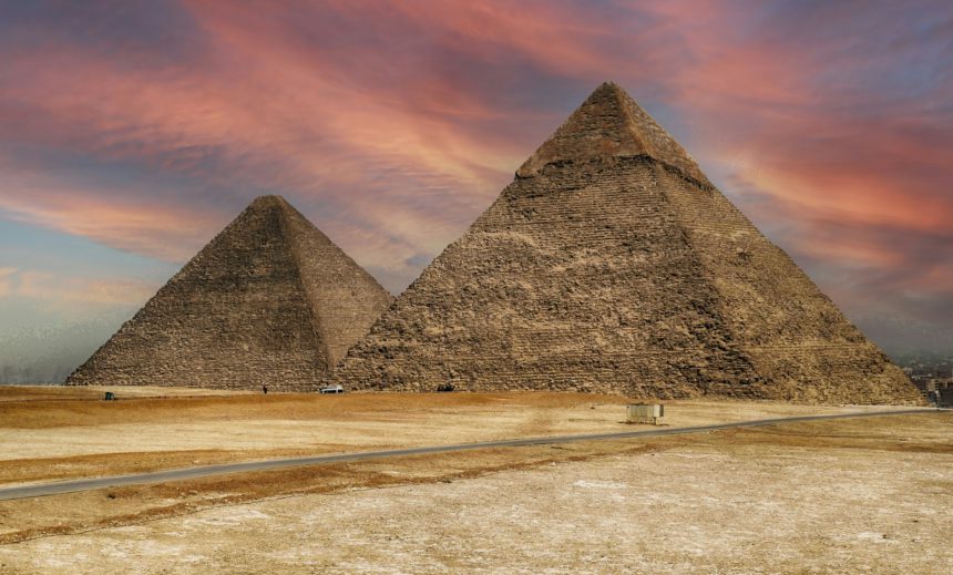 View of the pyramids of Giza in Egypt against a colorful sunset sky