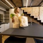 Woman unpacking groceries at modern kitchen