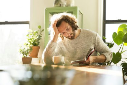 Young man reading book at home